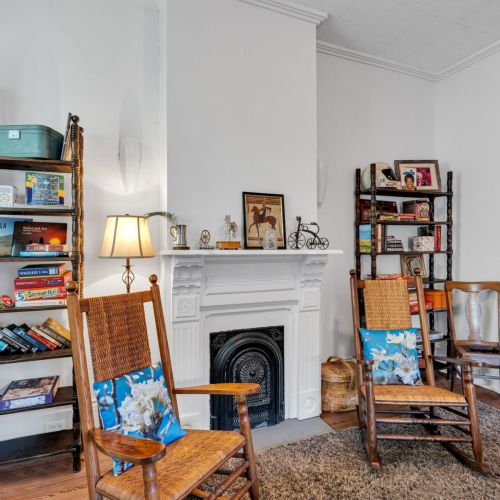 Cozy reading nook anchored by a classic fireplace.