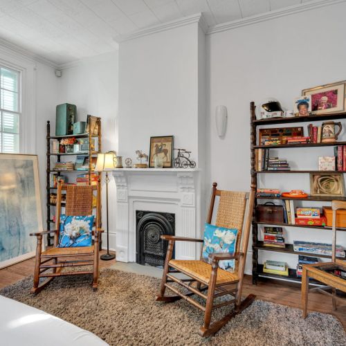 Classic NOLA living room w/ a cozy fireplace as its centerpiece.