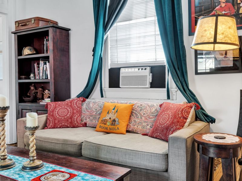 Comfy sofa piled w/ colorful pillows — made for relaxing evenings.