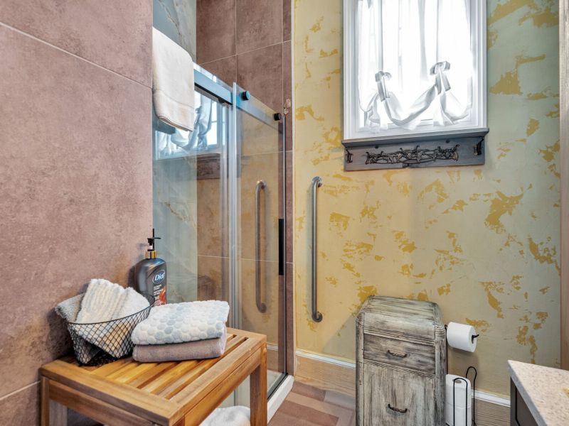 Sun-soaked bathroom w/ warm tones & a refreshing shower.