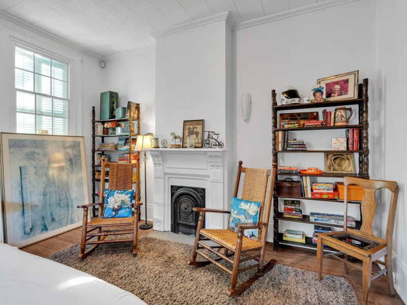 Classic NOLA living room w/ a cozy fireplace as its centerpiece.