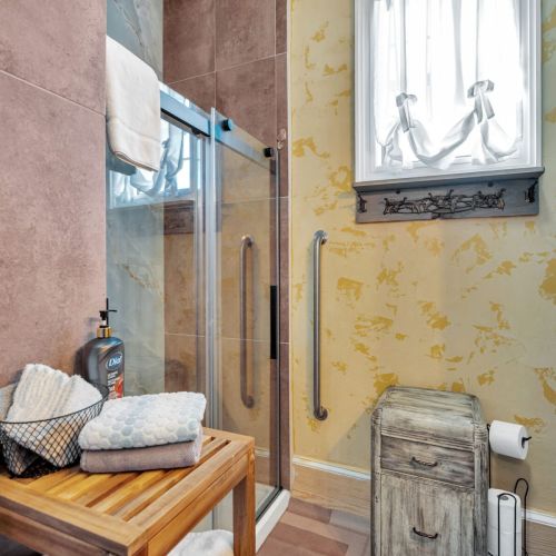 Sun-soaked bathroom w/ warm tones & a refreshing shower.