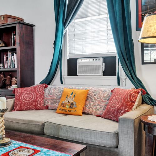 Comfy sofa piled w/ colorful pillows — made for relaxing evenings.